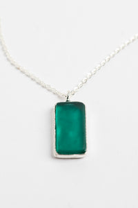 minimalist boho necklace pendant in teal on white background