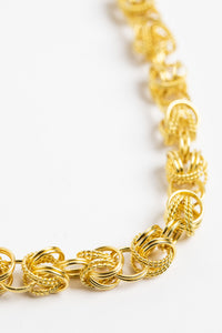 chunky gold chain necklace on white background