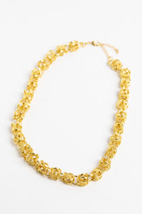 chunky gold chain necklace on white background