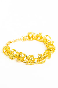 bold gold statement bracelet on white background