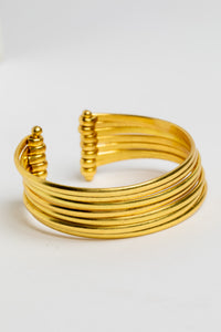 Bold statement wrist cuff in gold on white background