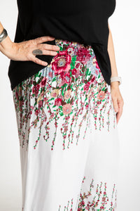 Betty is wearing floral palazzo pants in white