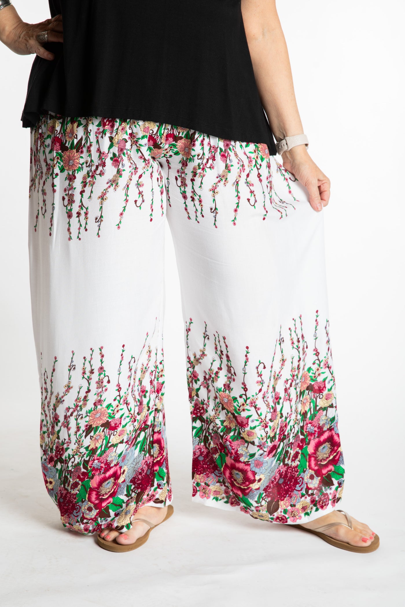 Betty is wearing floral palazzo pants in white