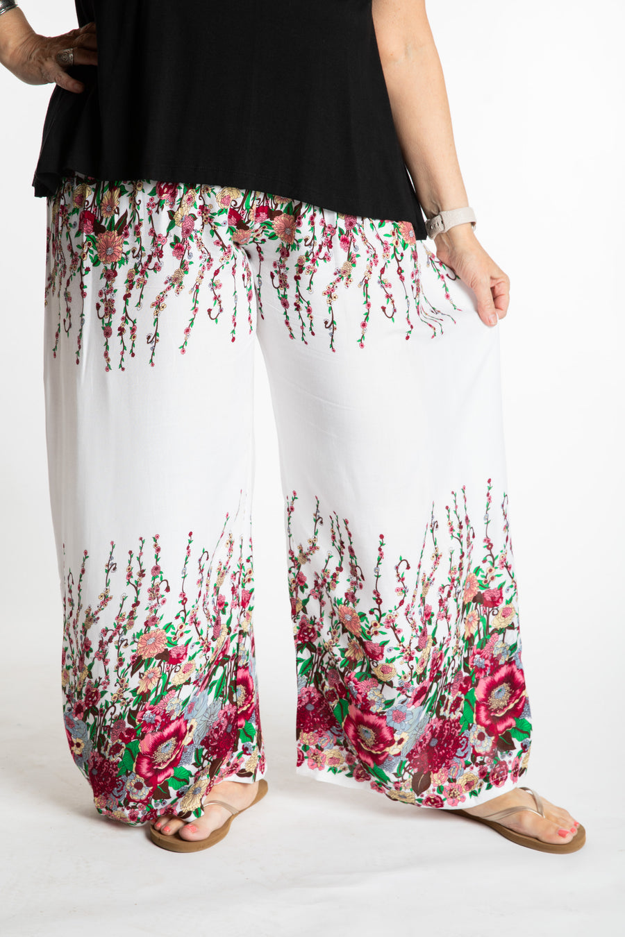 Betty is wearing floral palazzo pants in white