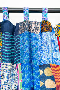 Blue patchwork curtain hanging on a curtain rod.