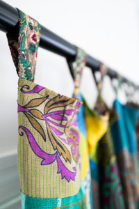 Colorful Green patchwork curtain with floral patterns hanging on a curtain rod