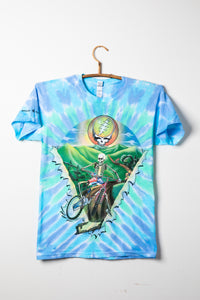 Grateful Dead tie-dye t-shirt with a skeleton on a bike graphic, against a white background.