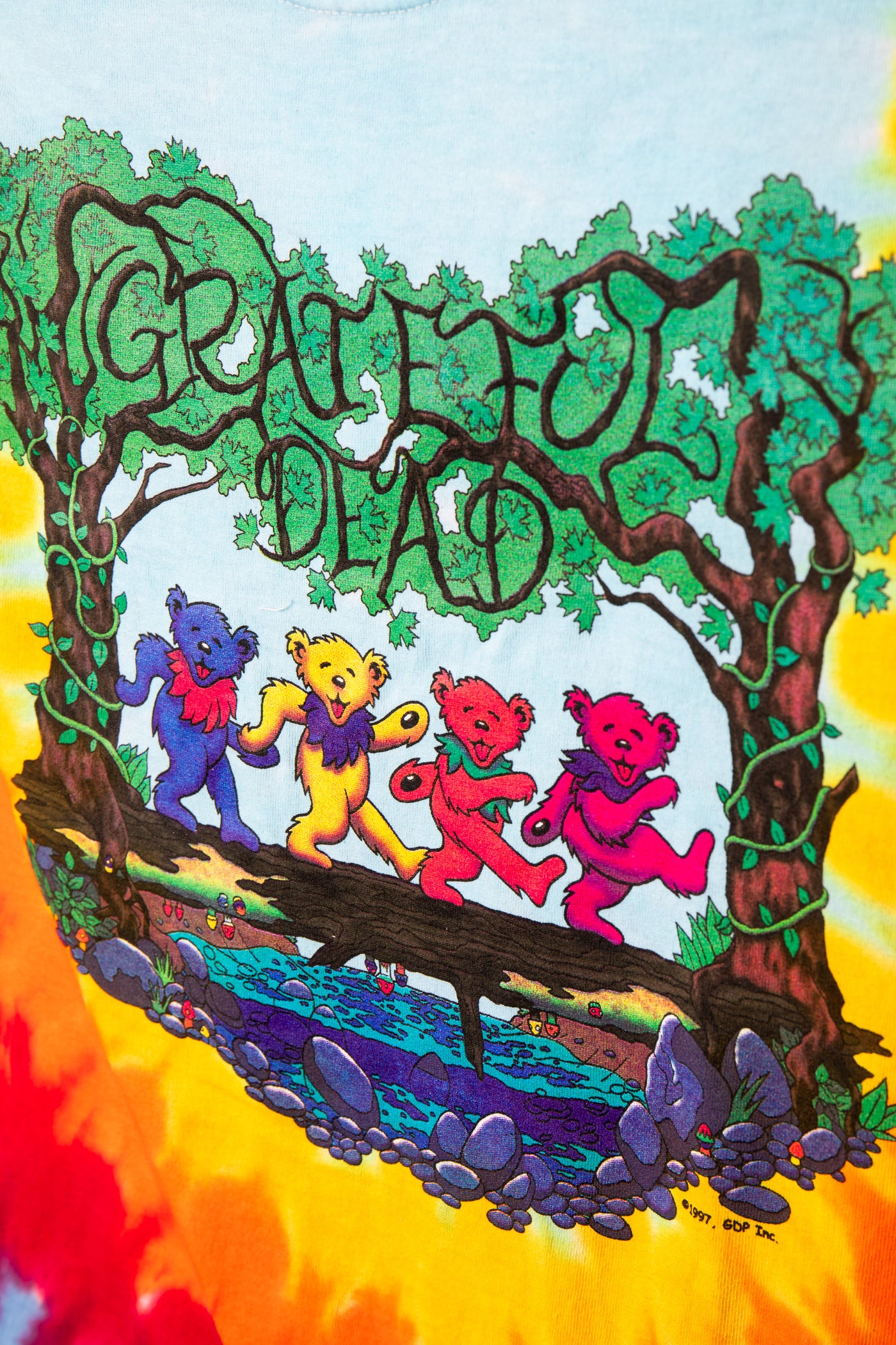 Colorful tie-dye t-shirt with Grateful Dead design featuring four dancing bears on a bridge.