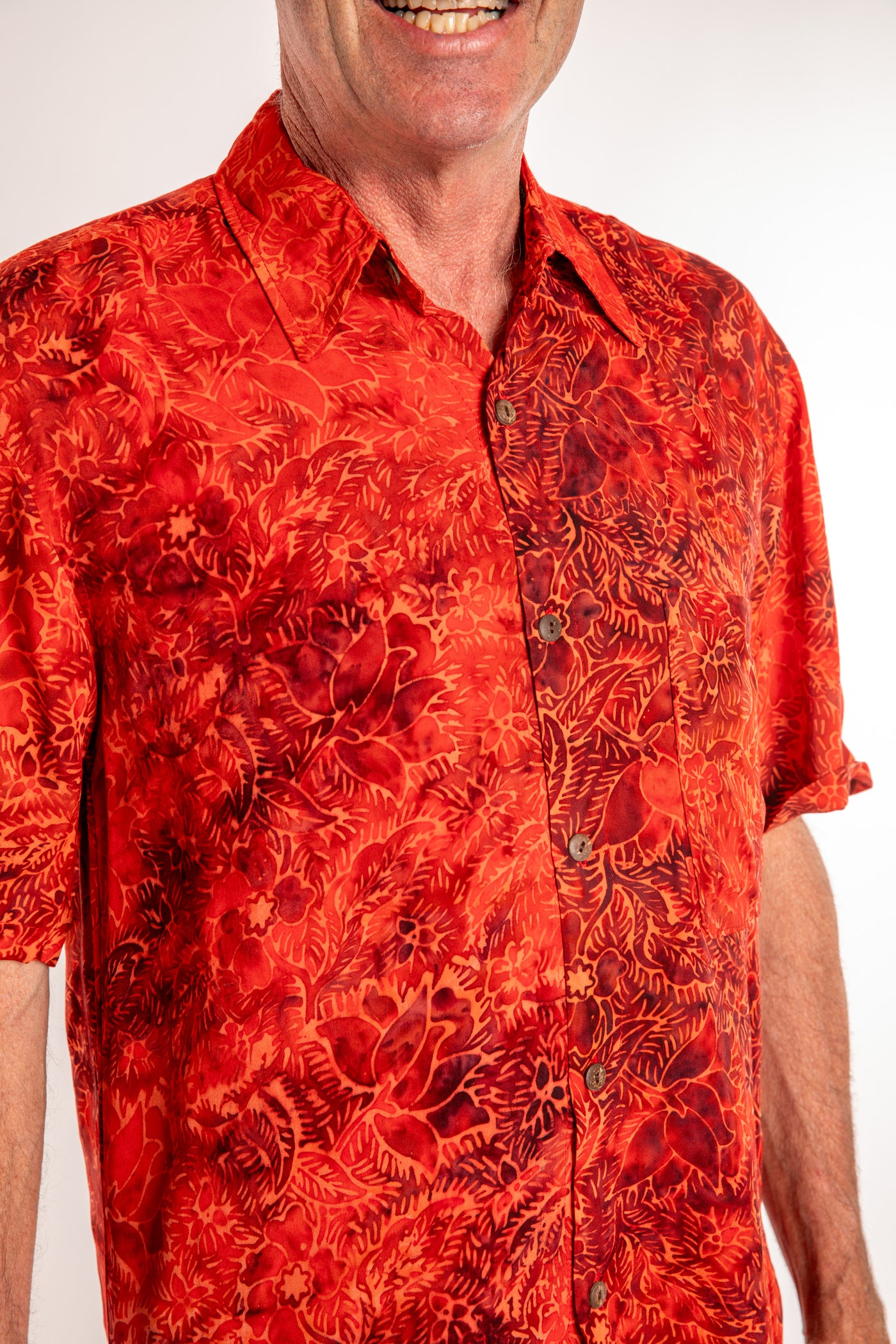 Ross wearing a M red floral batik shirt in Persimmon