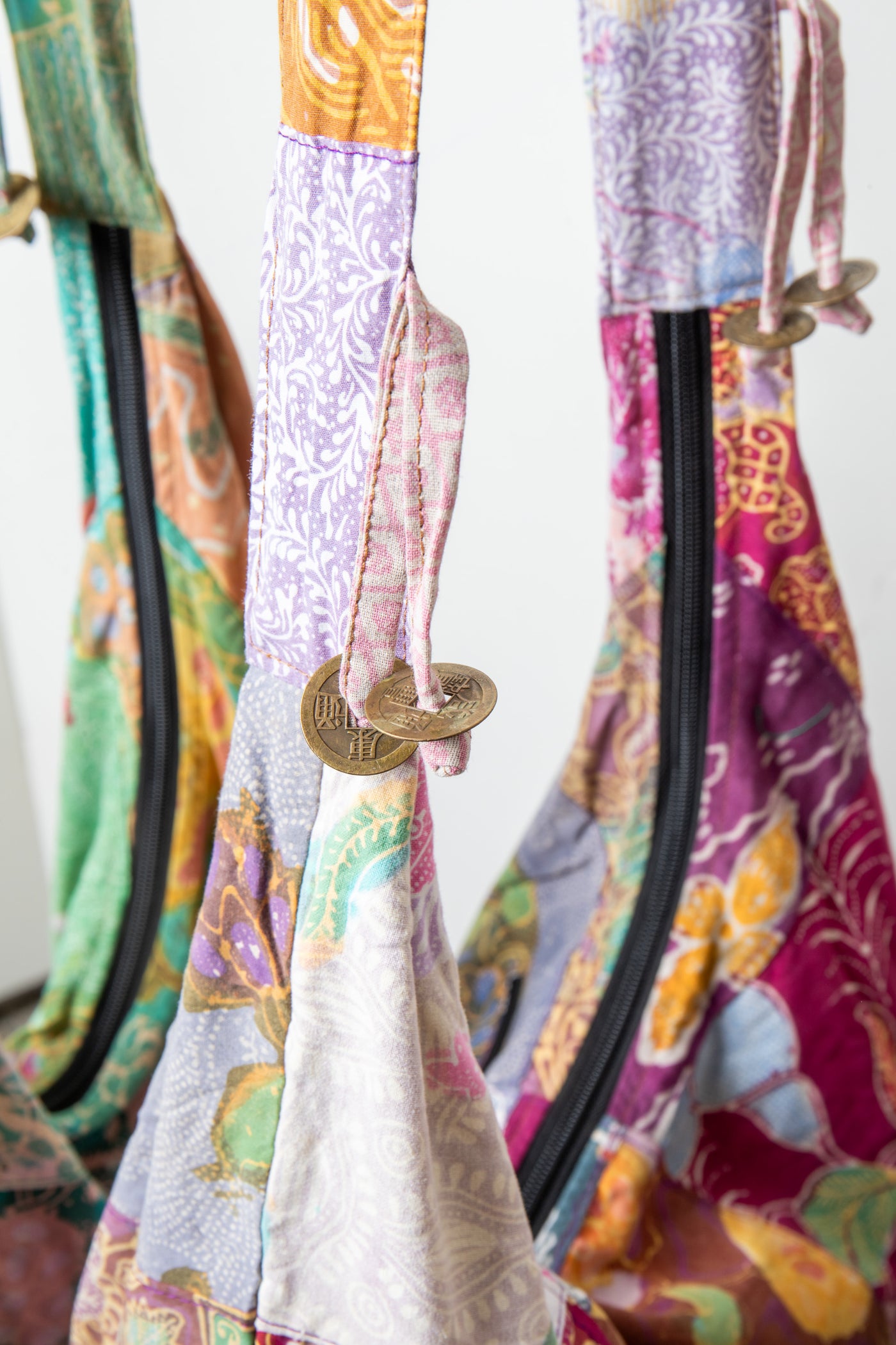 Assorted colorful patterned java patch moon bag detail of coin tassels