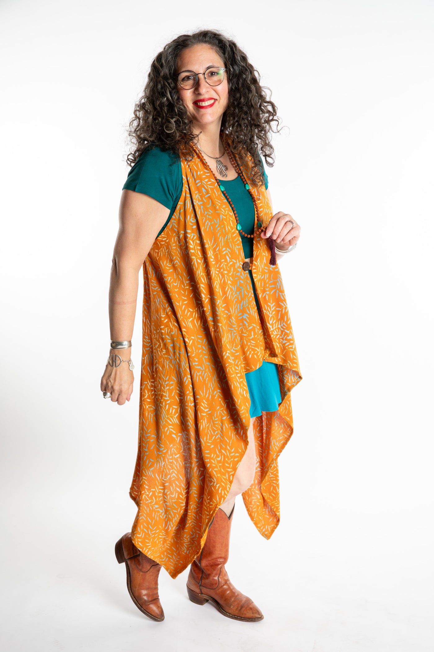 Susan wearing a long orange batik patterned vest in turmeric