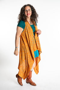 Susan wearing a long orange batik patterned vest in turmeric