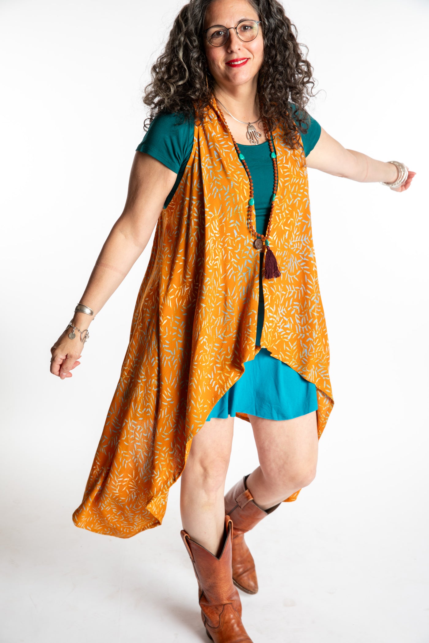Susan wearing a long orange batik patterned vest in turmeric