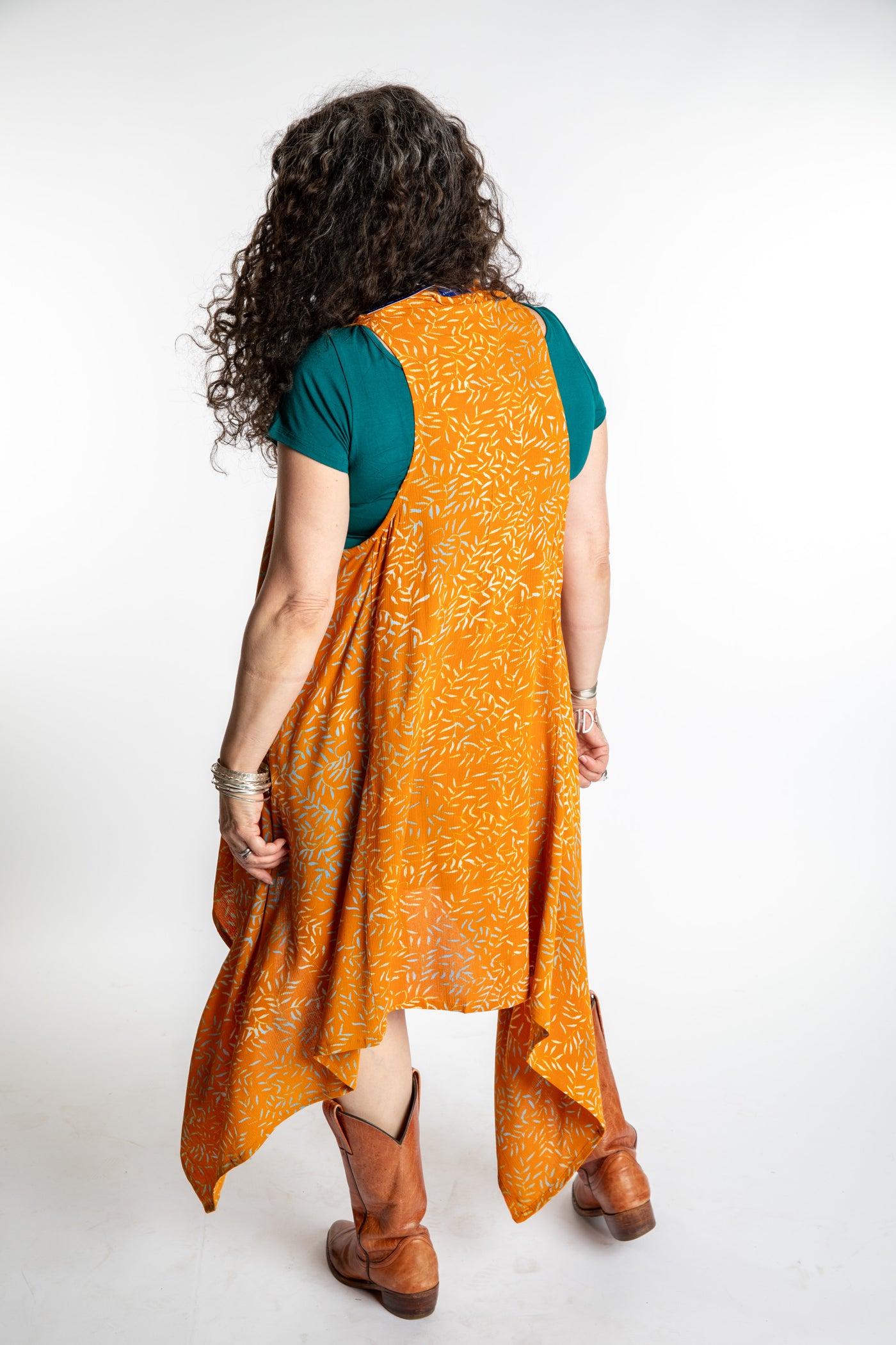 Susan wearing a long orange batik patterned vest in turmeric