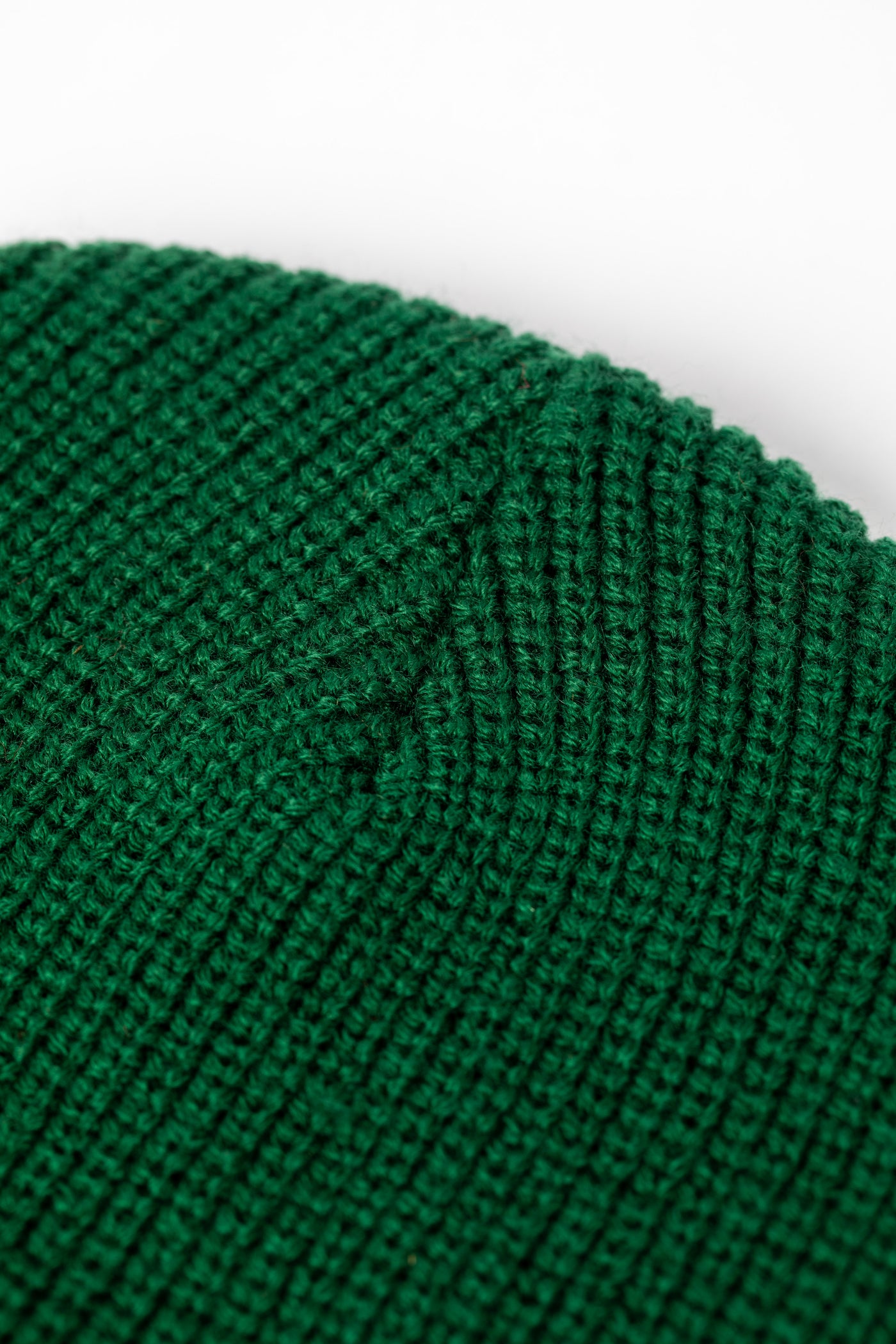 Detail of Forest Green knit acrylic beanie with a floral patch