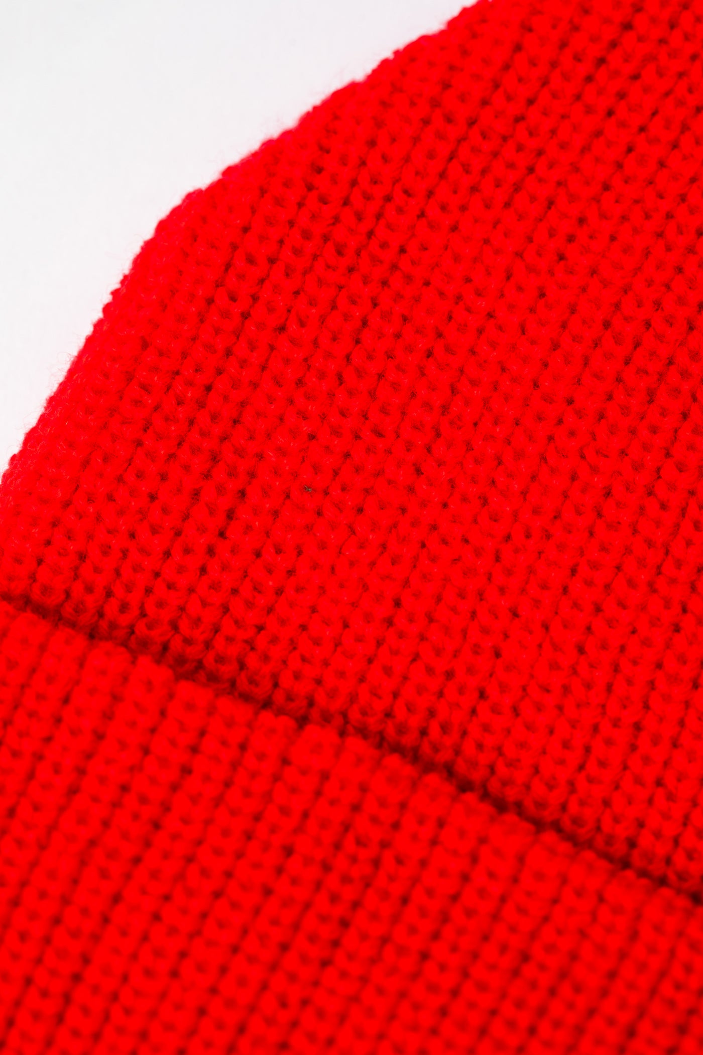 Detail of Orange Red knit acrylic beanie with a wildflower patch