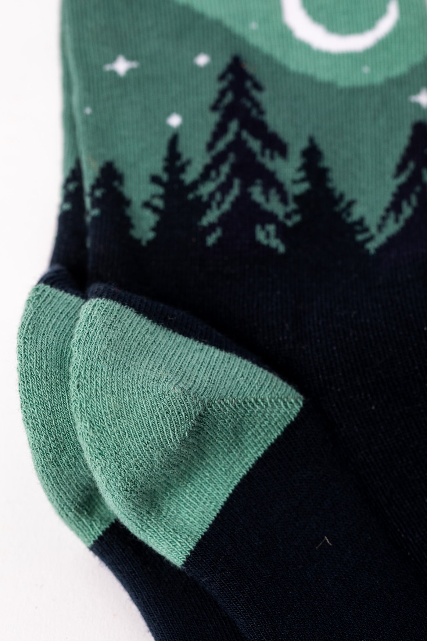 Pair of Teal socks with a forest and night sky design