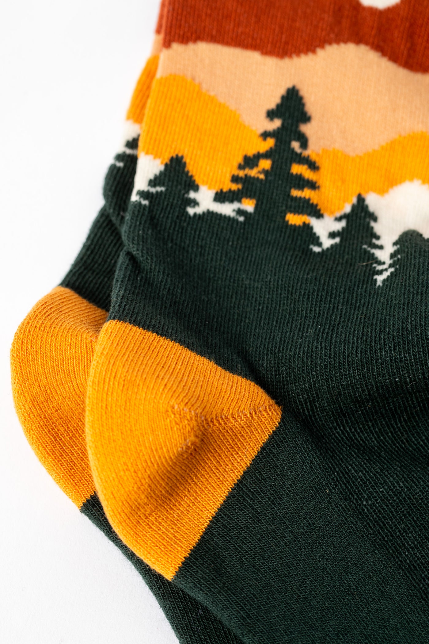 Multicolor green socks with orange accents and a nature-themed design.