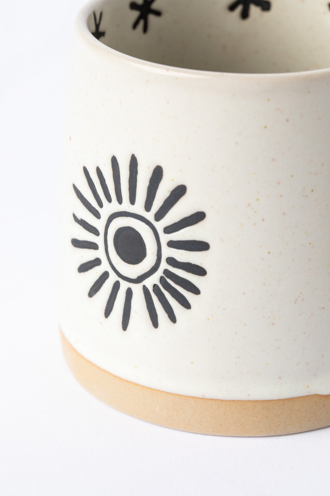 Close-up of sun design in black on Crescent Moon and Sun Mug.