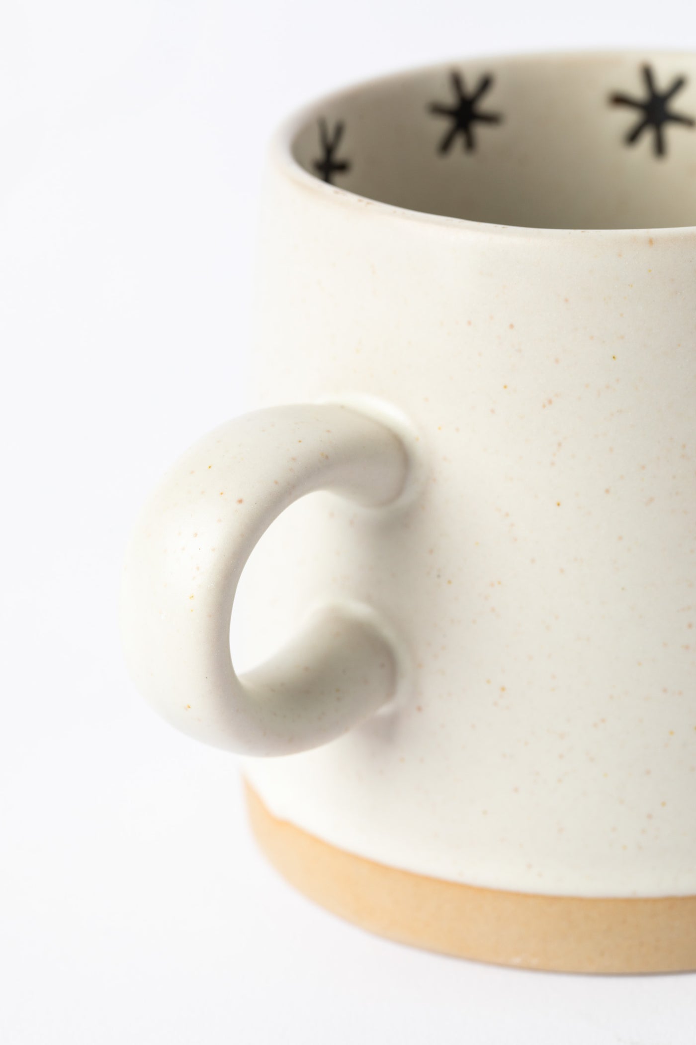 Detail of the raw clay base and soft matte glaze on Crescent Moon and Sun Mug.