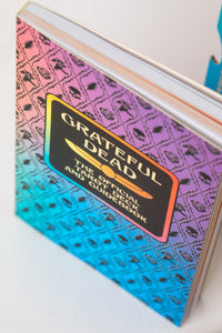 Grateful Dead Tarot guidebook with rainbow skull-and-rose pattern on cover.