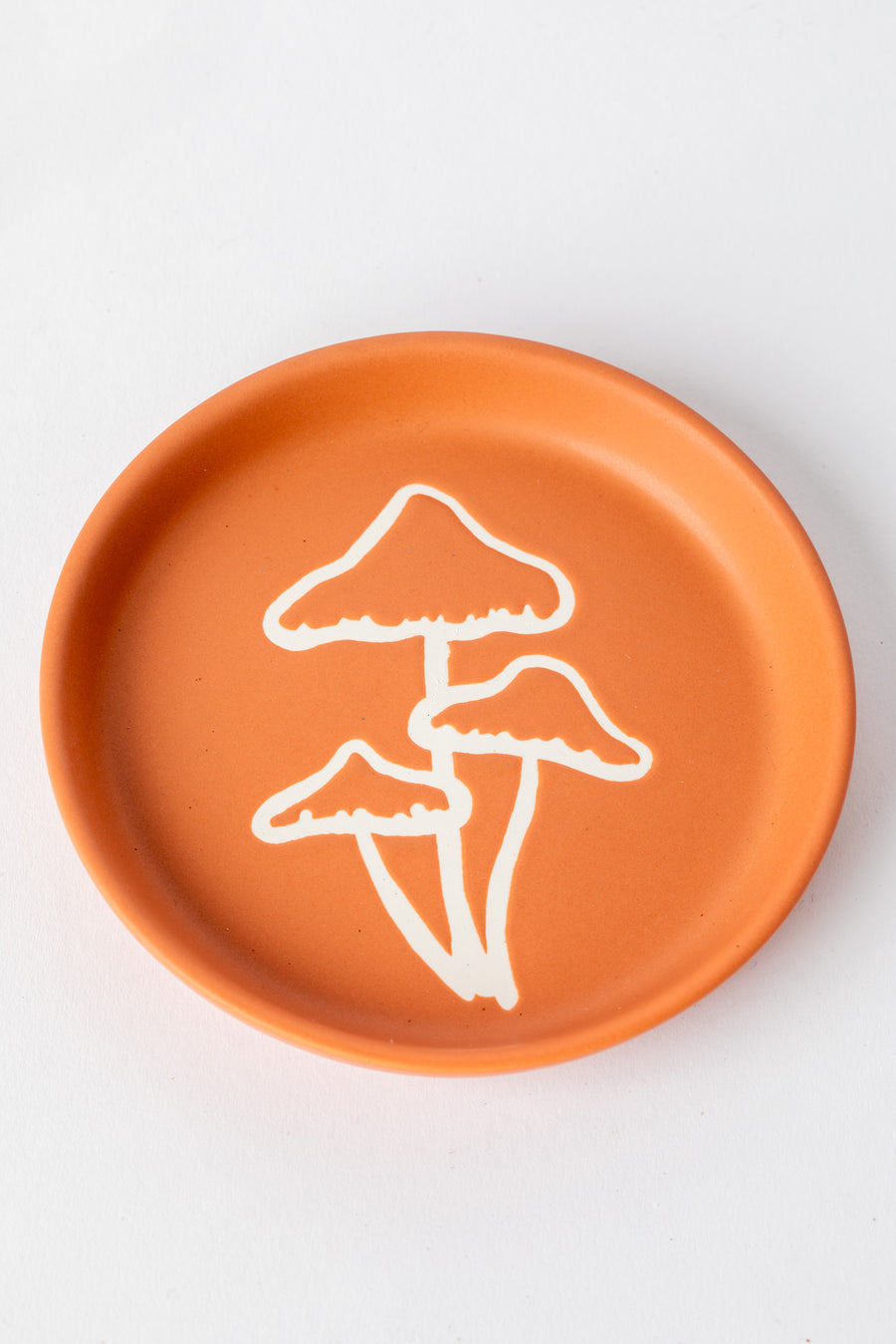 Terracotta coaster with white mushroom illustration