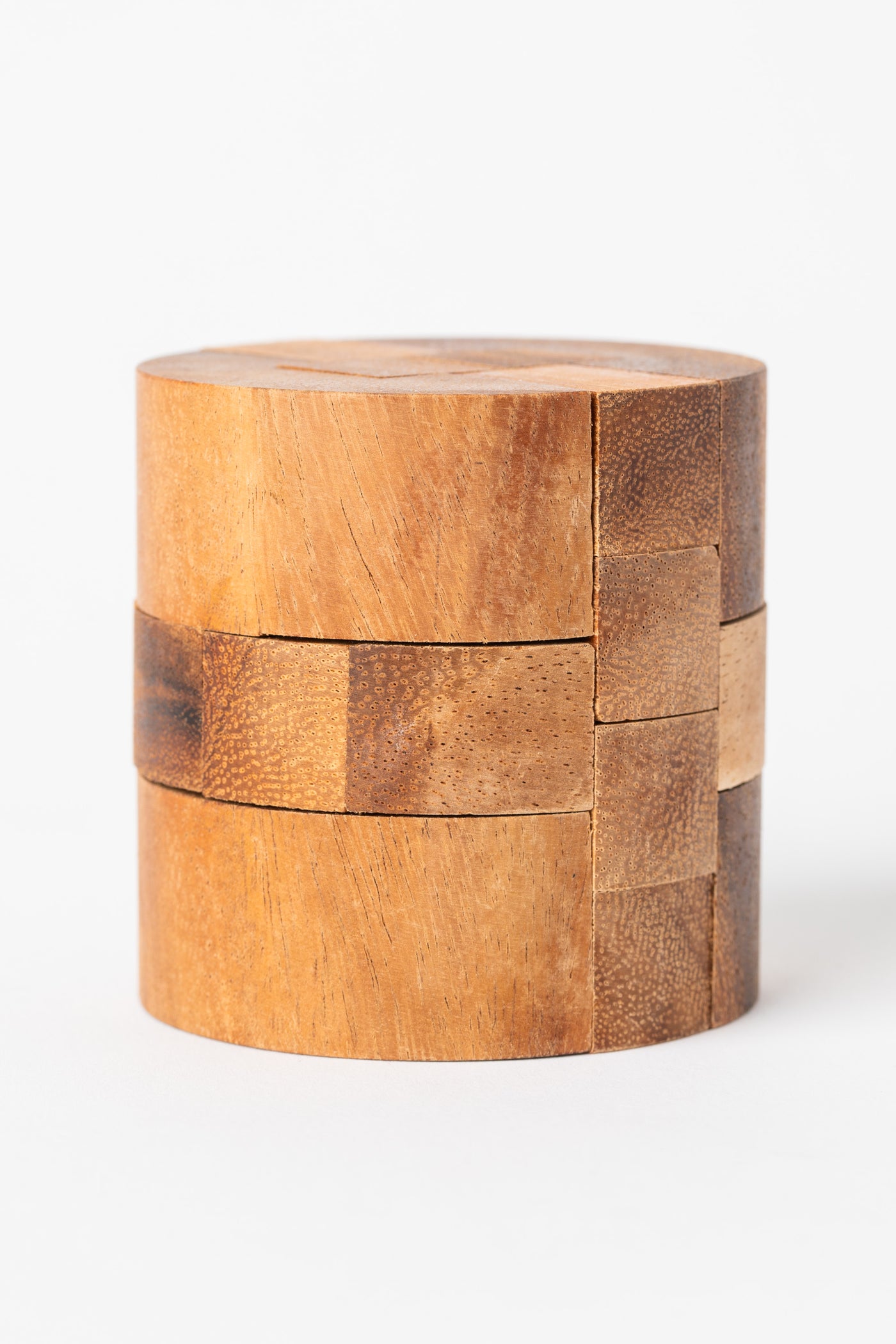 Side view of cylinder puzzle showing wood grain pattern and tight fit of puzzle pieces.