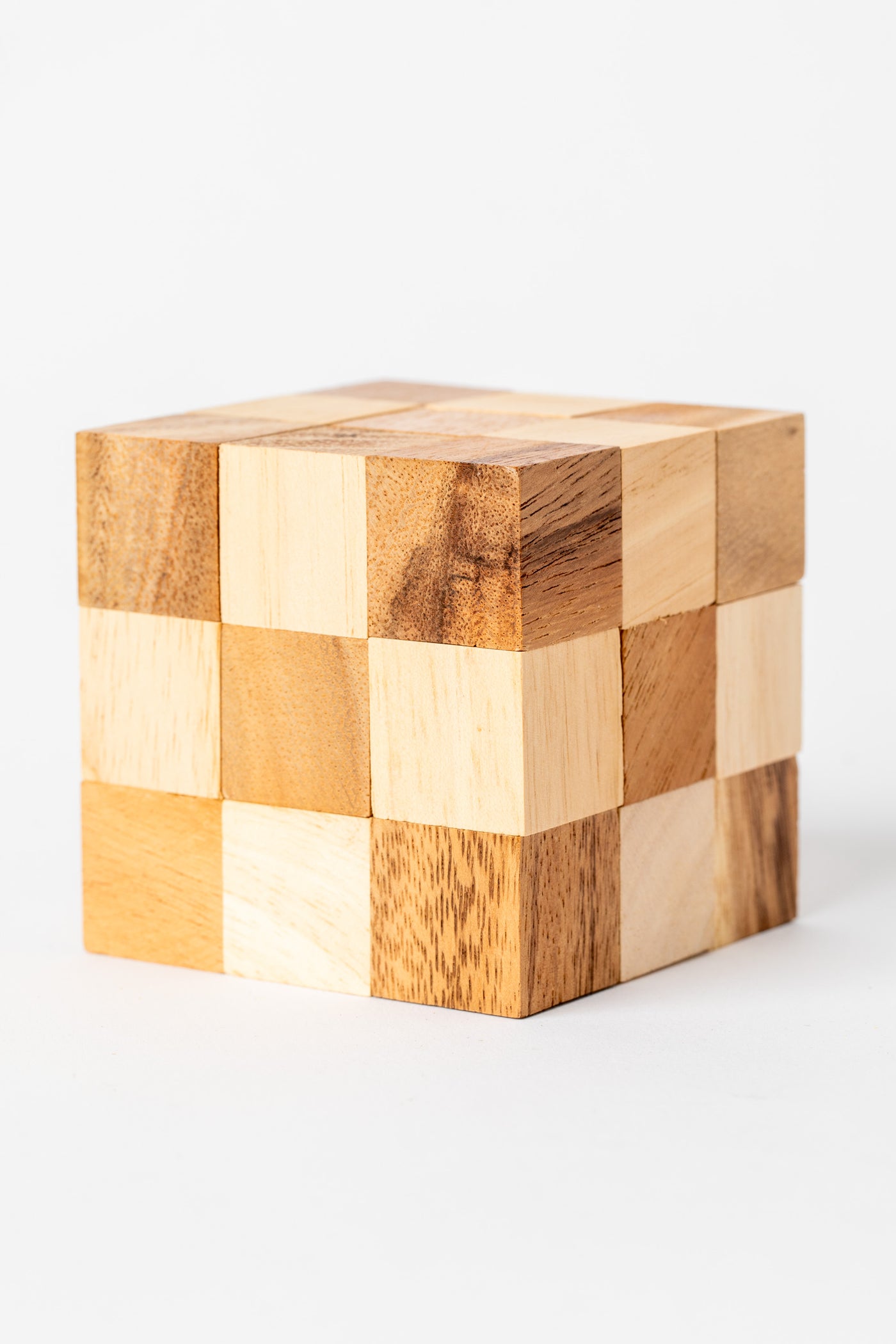 Handmade wooden cube puzzle made from natural light and dark wood blocks for a classic brain teaser look.