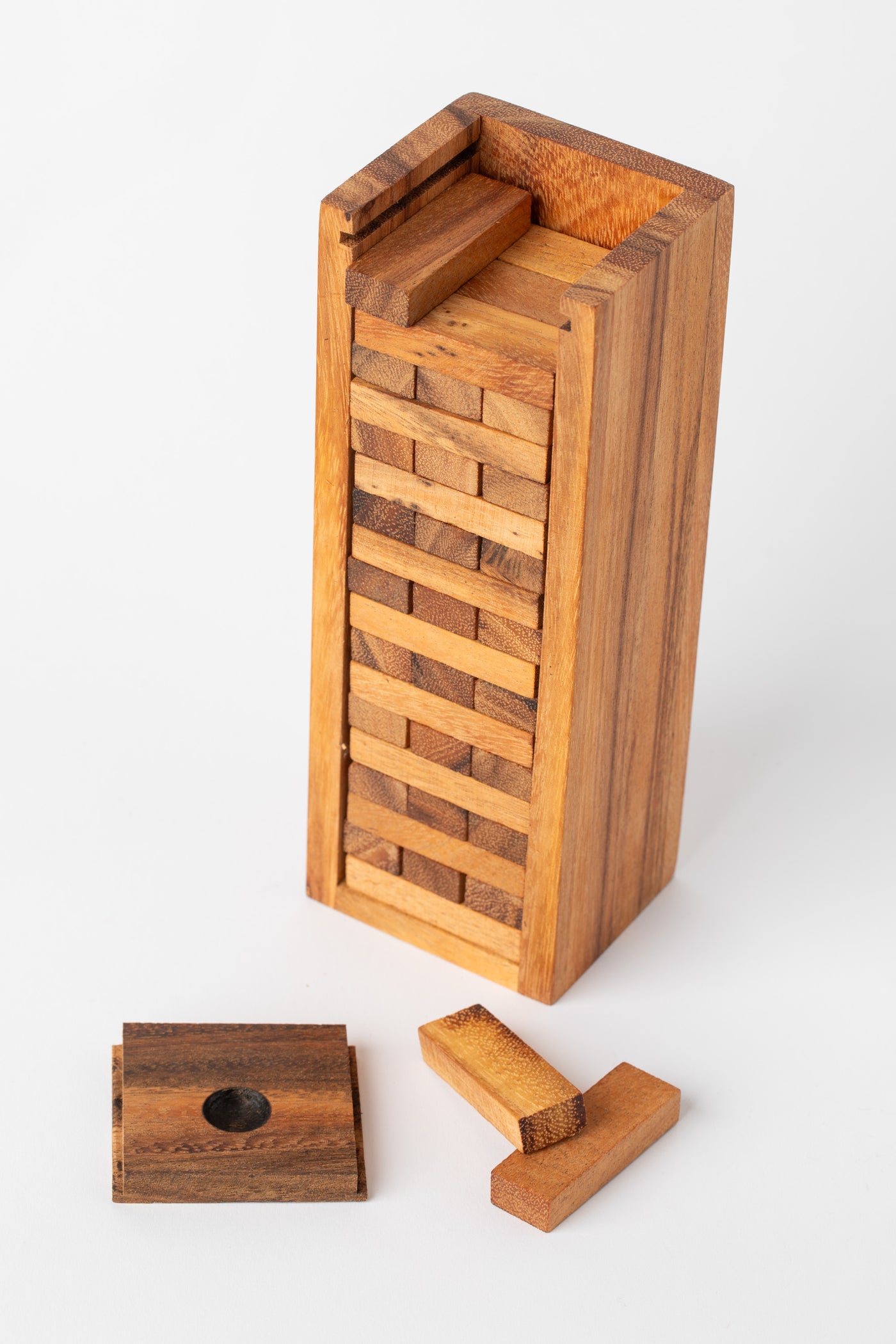 Timber Tumble wooden tower game with blocks removed and placed beside case — handcrafted wood stacking game for families.