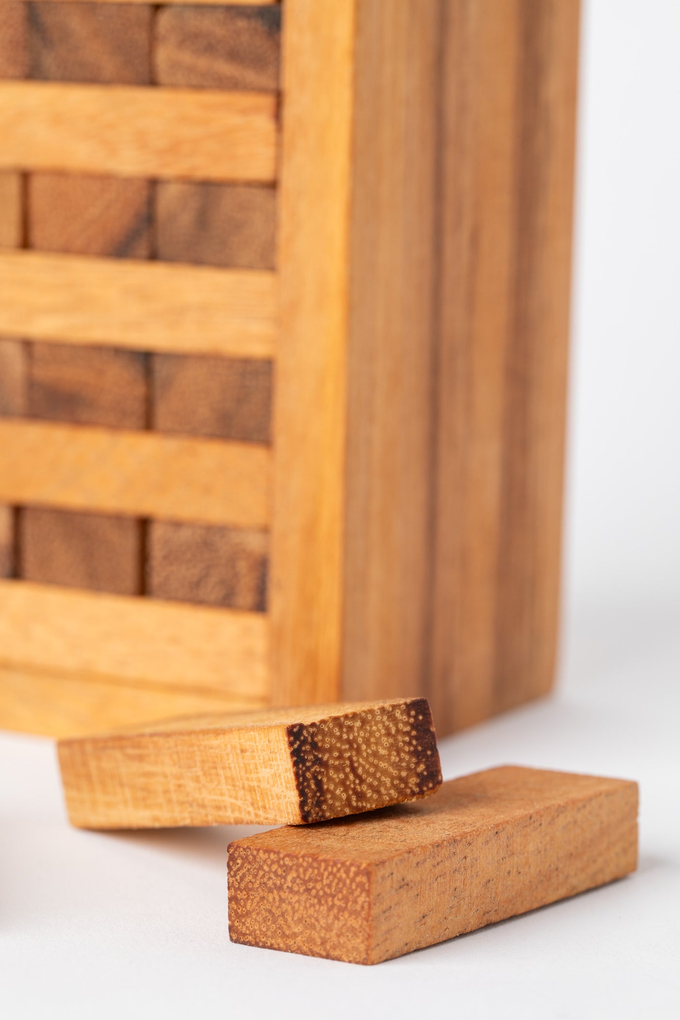 Close-up of natural wood stacking blocks with visible texture and grain — artisan wooden game made in Thailand.