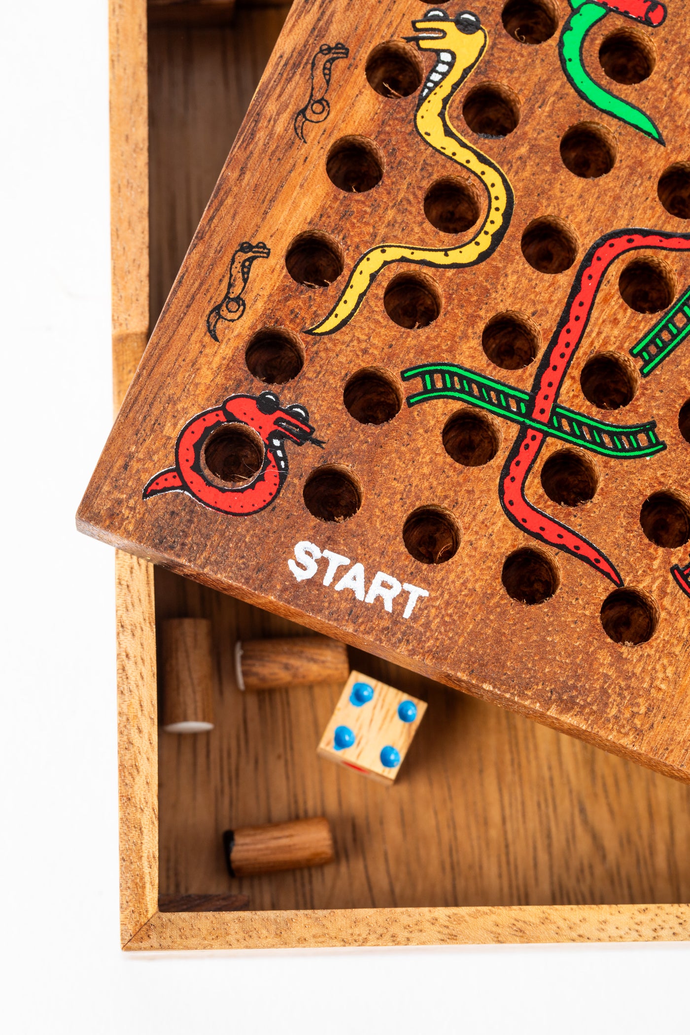 Wooden snakes and ladders game board with hidden storage compartment showing dice and pegs — artisan wooden game handmade in Thailand.