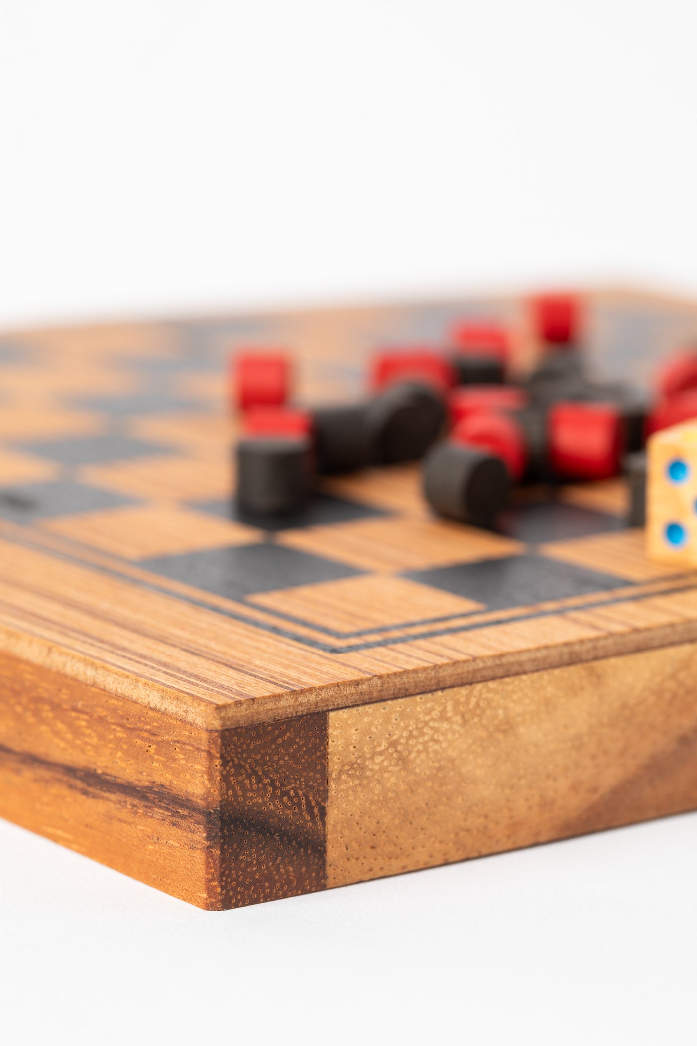 Close-up of handcrafted wooden board edge showing fine grain and smooth finish — artisan board game.