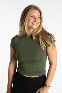 Sophie is wearing the S/M Green Chara Crew Neck Top