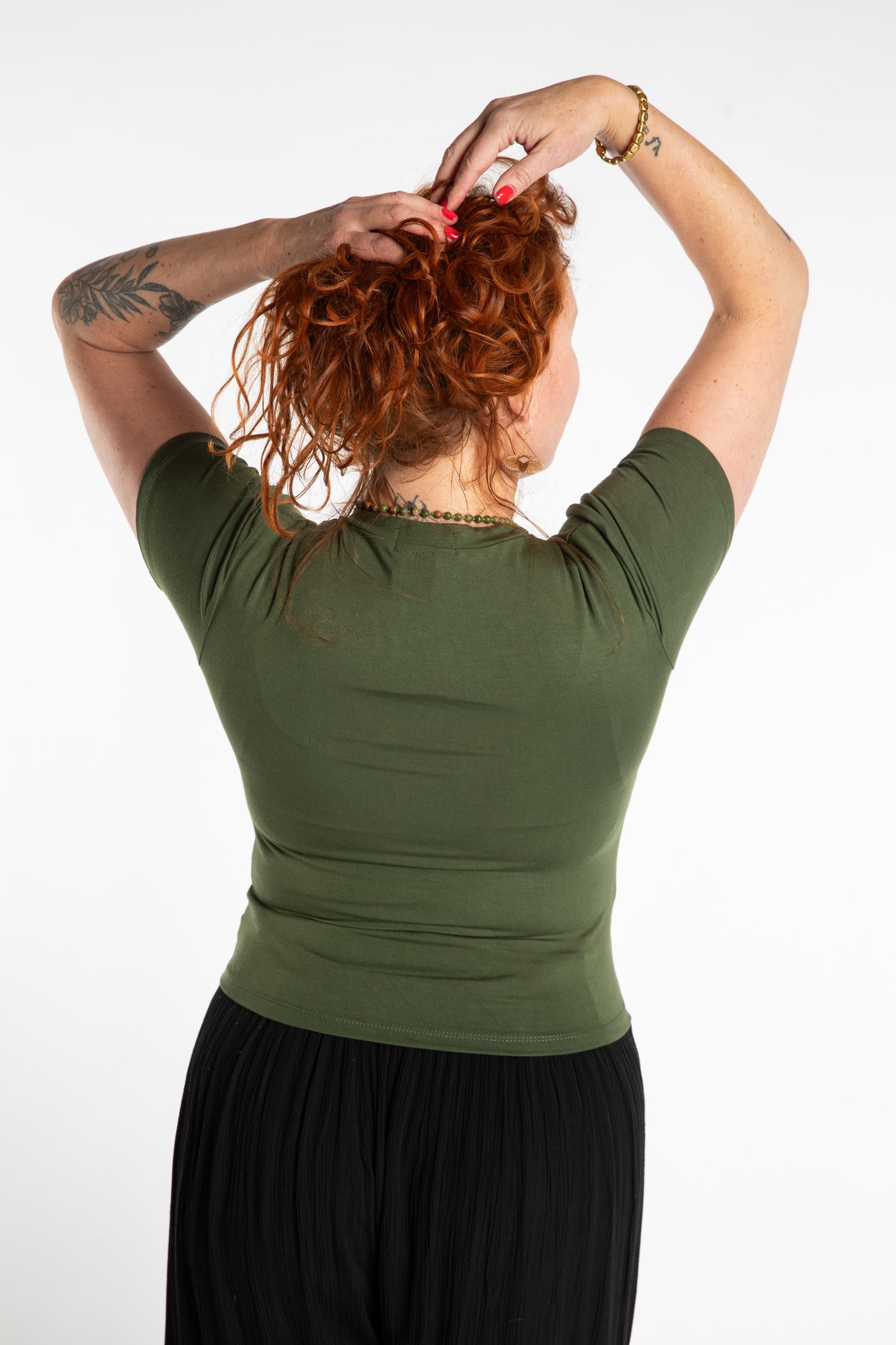 Maggie is wearing the M/L Green Chara Crew Neck Top