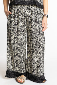 Betty wearing size M/L Black Primrose floral Penny Lane contrast hem wide leg pants