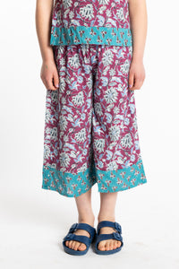 Louisa age 7 wearing Penny Lane Contrast Hem Kids Pants in burgundy floral print, size Small