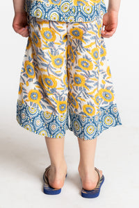Louisa age 7 wearing Penny Lane Contrast Hem Kids Pants in sunflower print, size Small