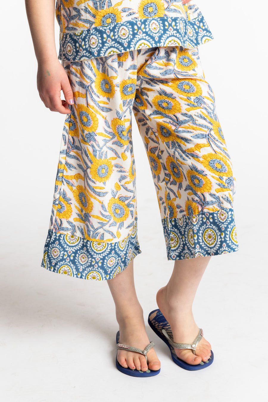 Louisa age 7 wearing Penny Lane Contrast Hem Kids Pants in sunflower print, size Small
