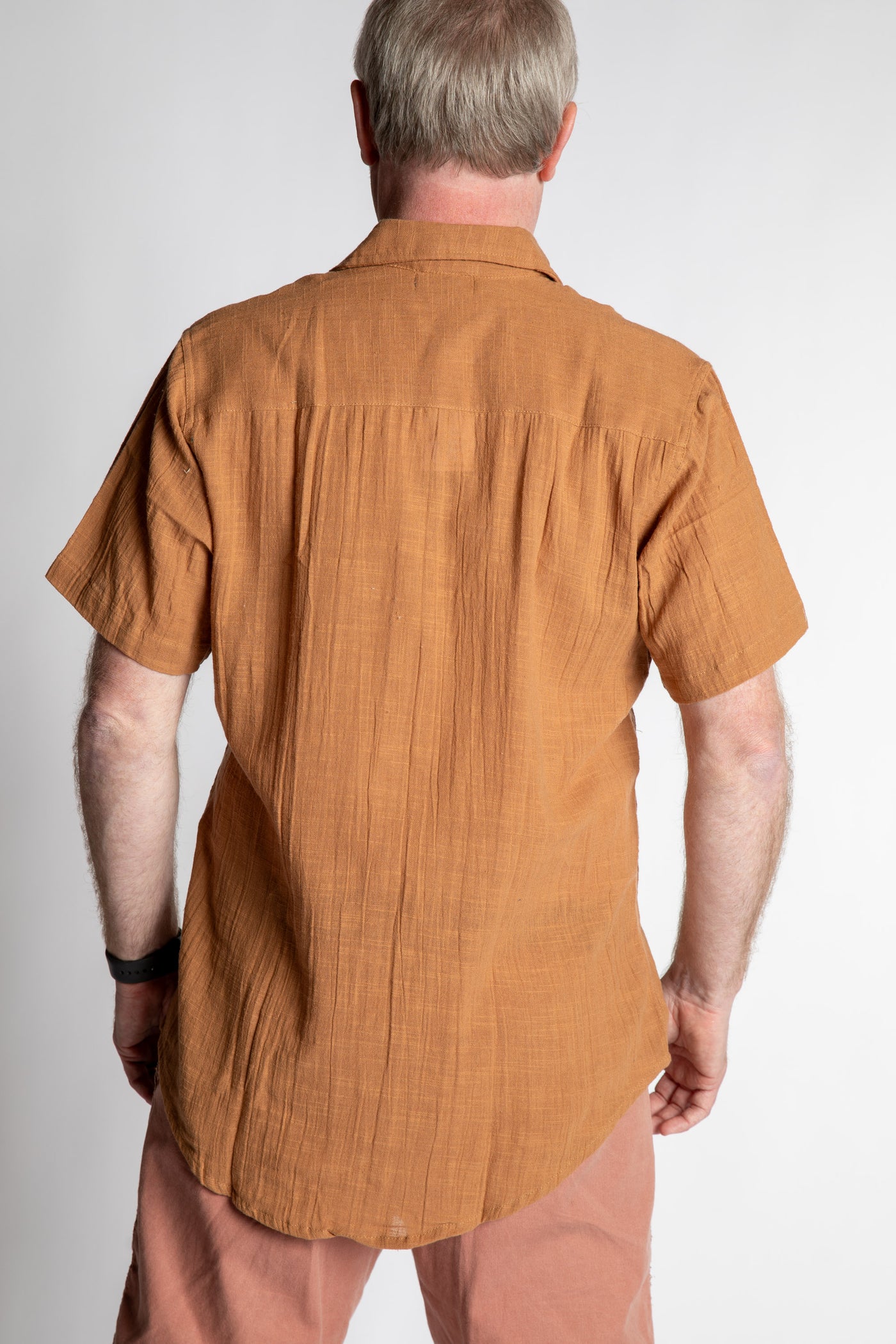 Chris, 5'7", wearing the Chandani Cotton Button Up in orange brown, size M