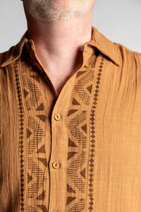 Chris, 5'7", wearing the Chandani Cotton Button Up in orange brown, size M