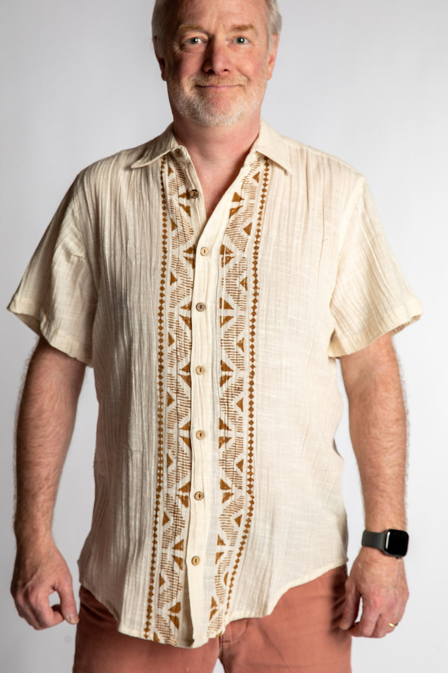 Chris, 5'7", wearing the Chandani Cotton Button Up in ivory white, size M