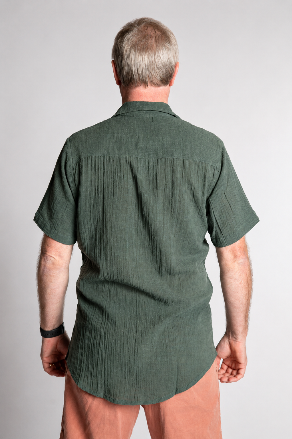 Chris, 5'7", wearing the Chandani Cotton Button Up in moss green, size M