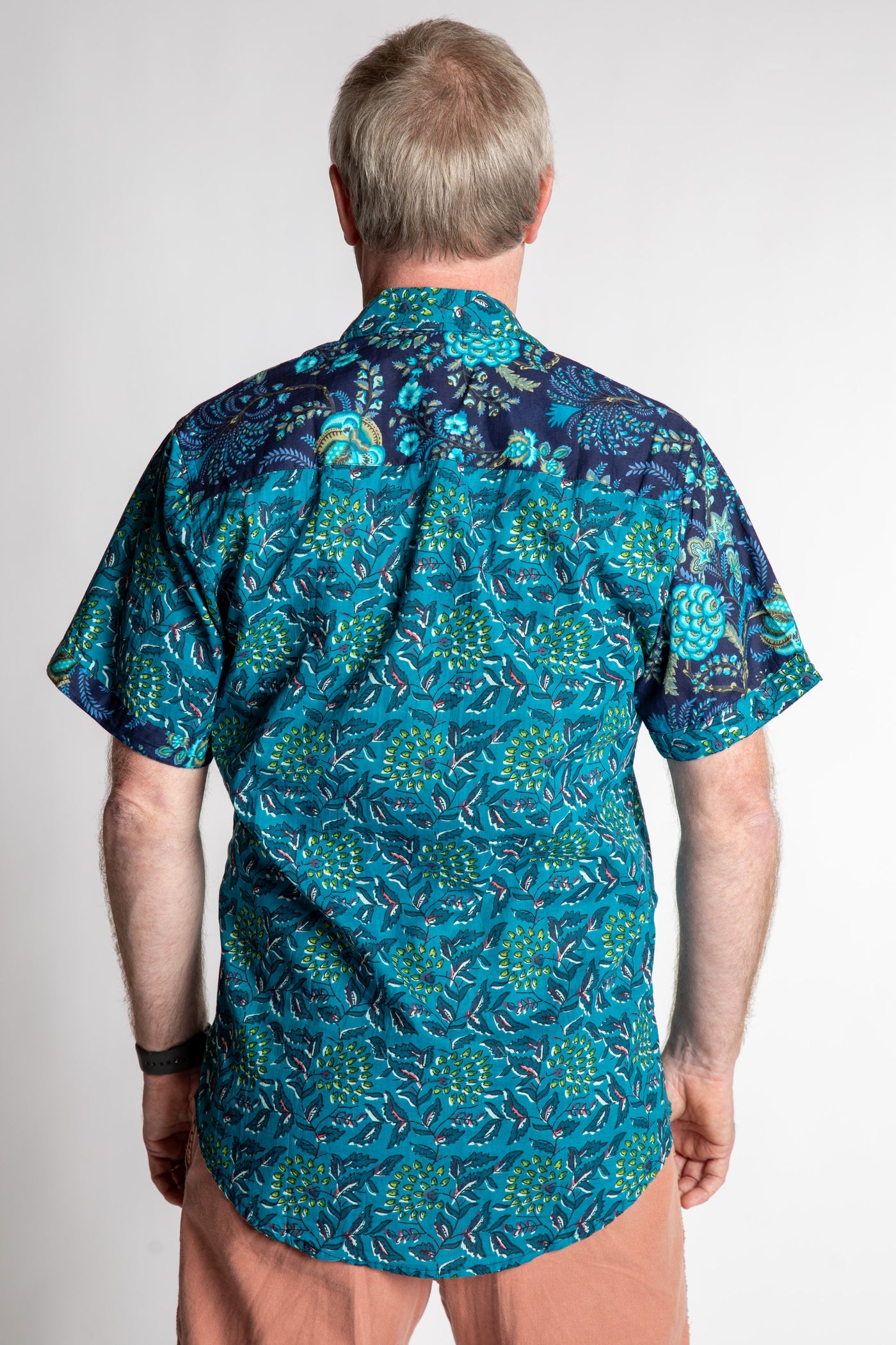 Chris, 5'7", is wearing the Field Fusion Button Up in navy blue floral print, size M