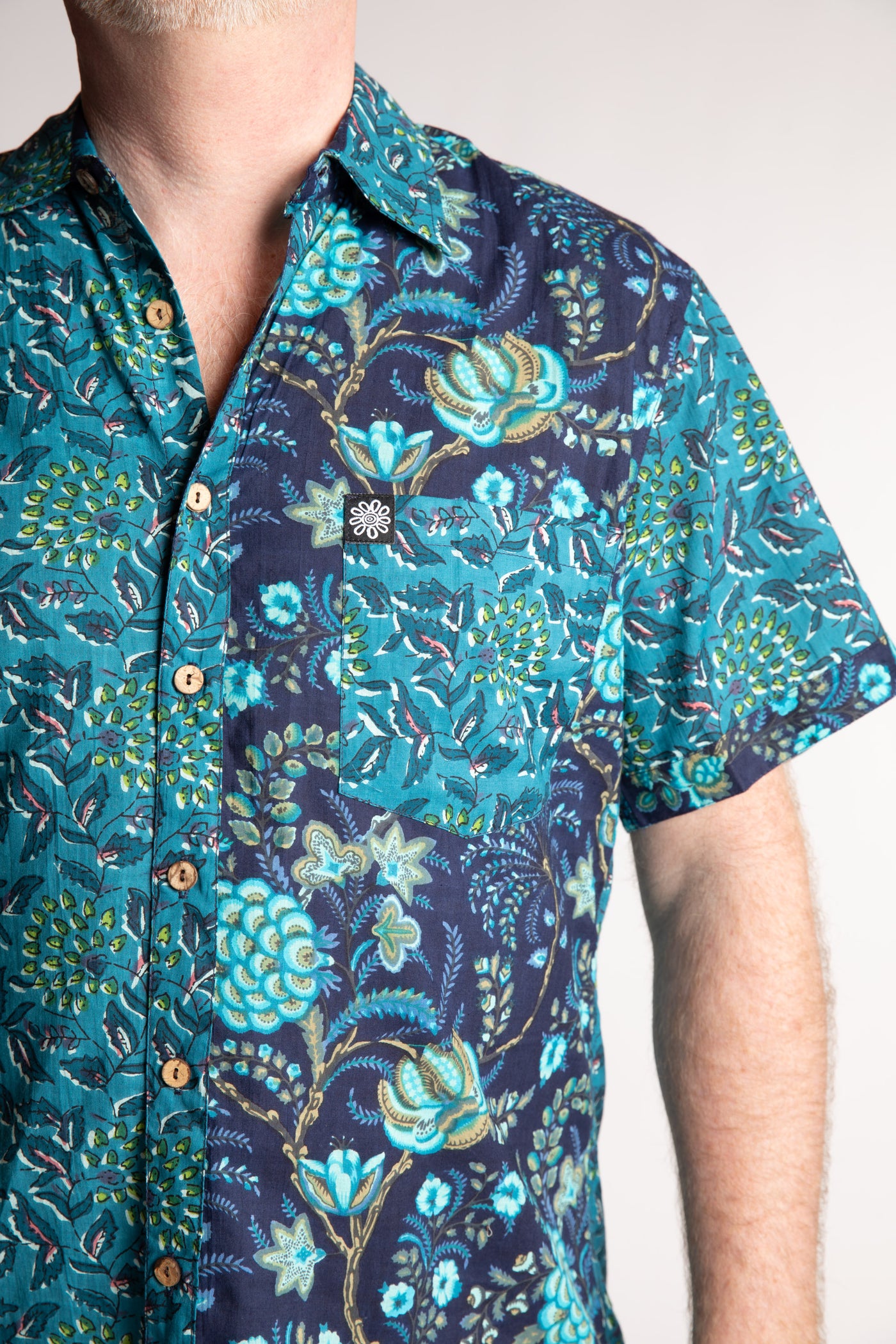 Chris, 5'7", is wearing the Field Fusion Button Up in navy blue floral print, size M