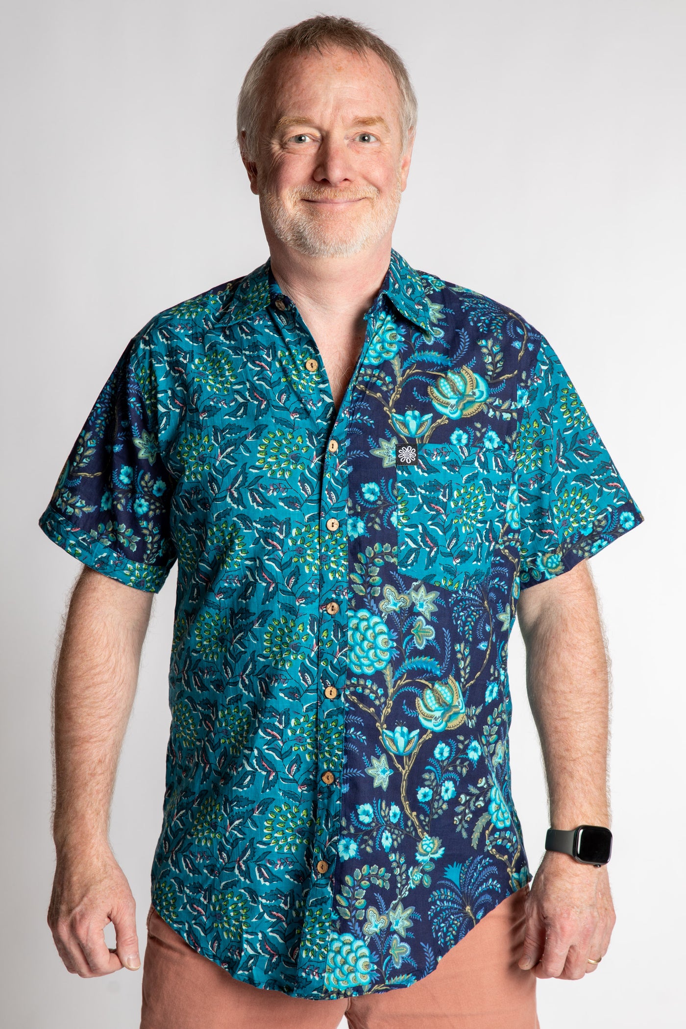 Chris, 5'7", is wearing the Field Fusion Button Up in navy blue floral print, size M