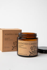 Hand-poured amber glass Apothecary Jar Candle beside kraft box with black lid
