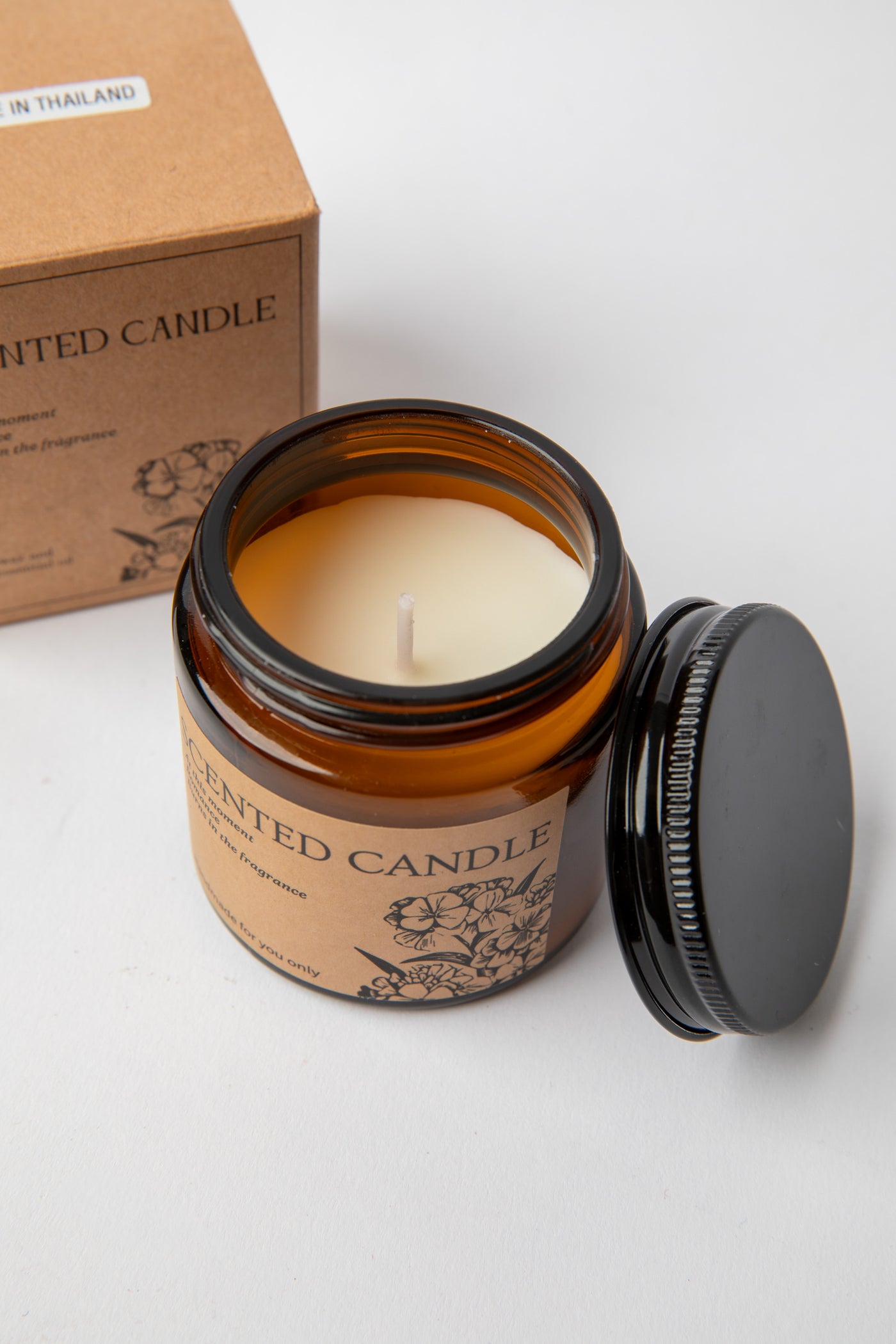 Hand-poured amber glass Apothecary Jar Candle beside kraft box with black lid