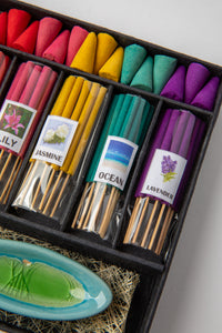 Close-up of rainbow incense cones and sticks labeled with floral and ocean scents in gift box packaging