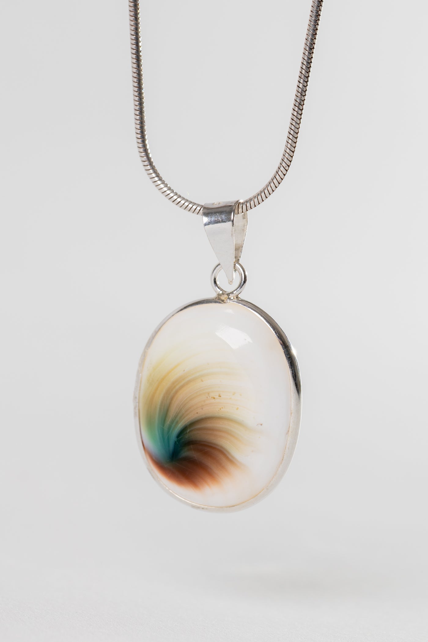 Sterling Shiva eye pendant with natural shell spiral pattern