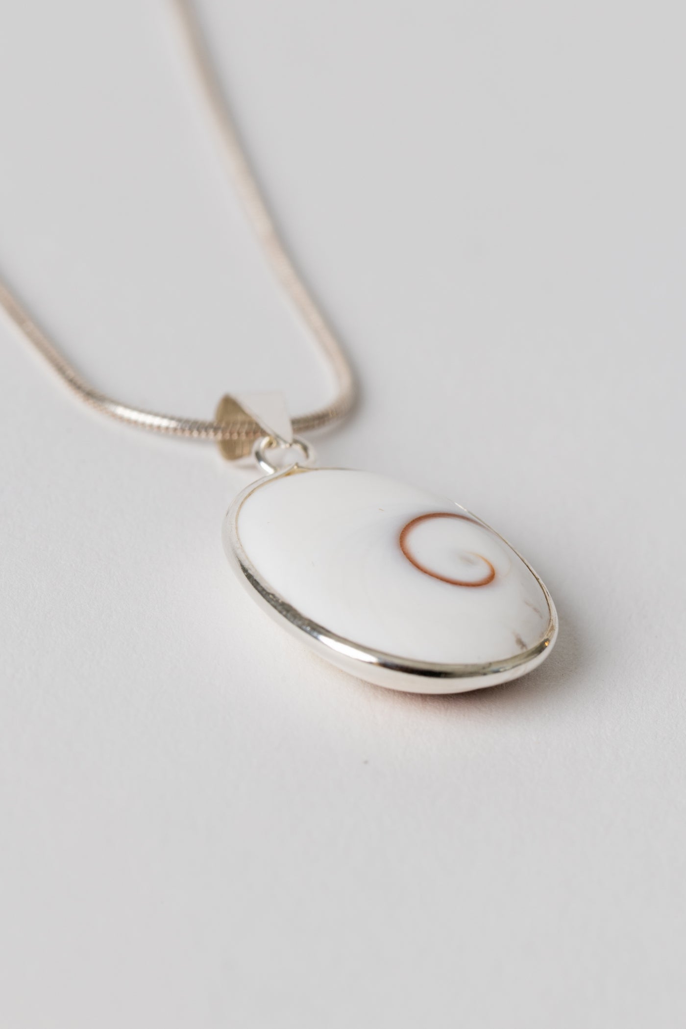 Sterling Shiva eye pendant with natural shell spiral pattern